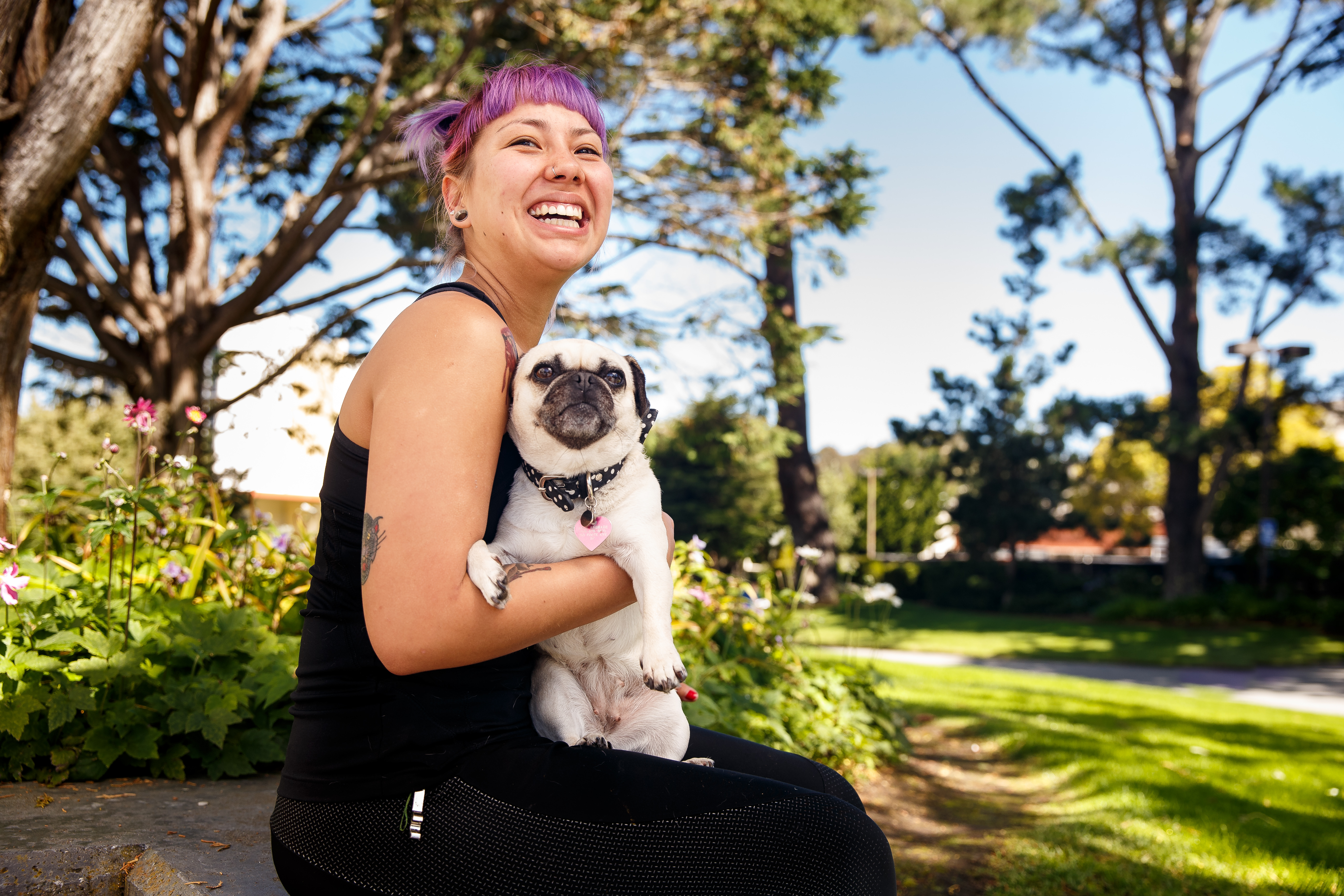 student holding a dog and smiling